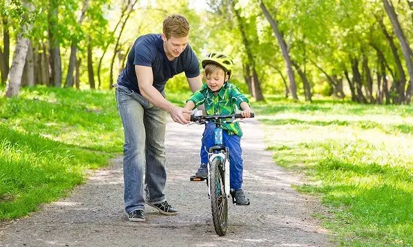 plimbarea unui copil pe o bicicletă cu două roți